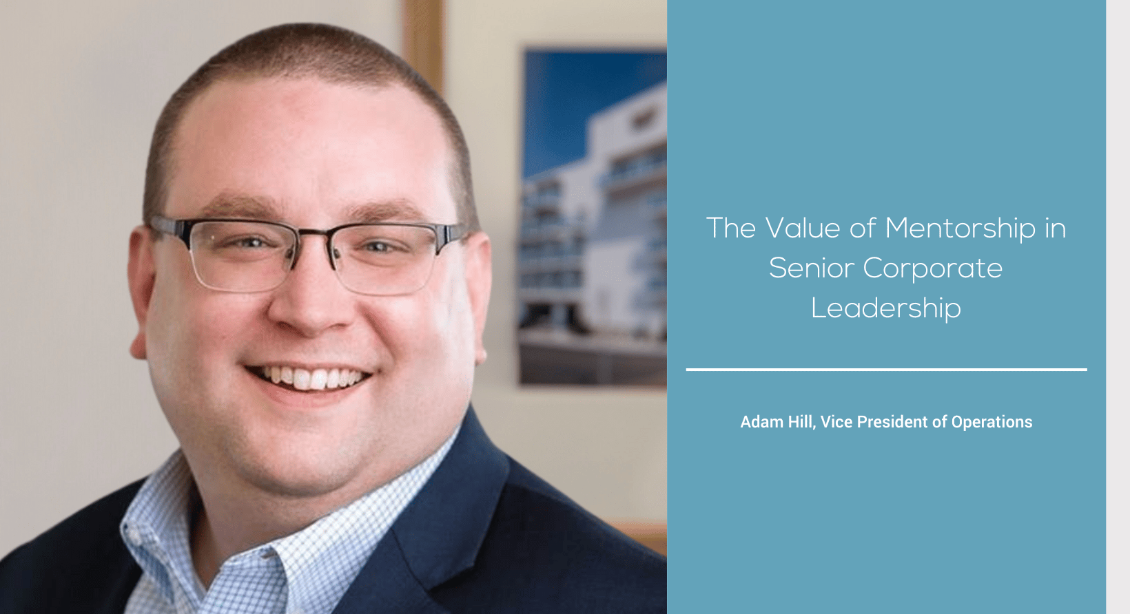 a man in a suit and glasses smiles at the camera