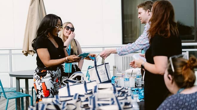 Marketing employees handing out leadership bags