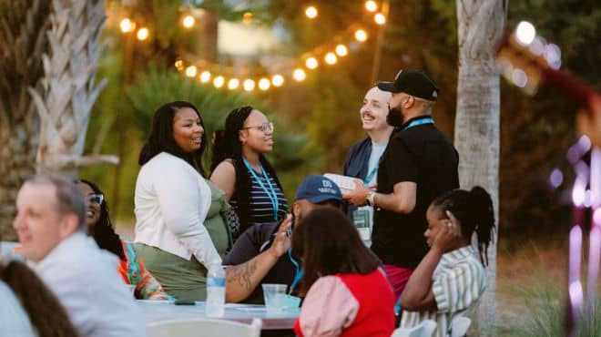 Retreat members gathered outdoors under a string of lights