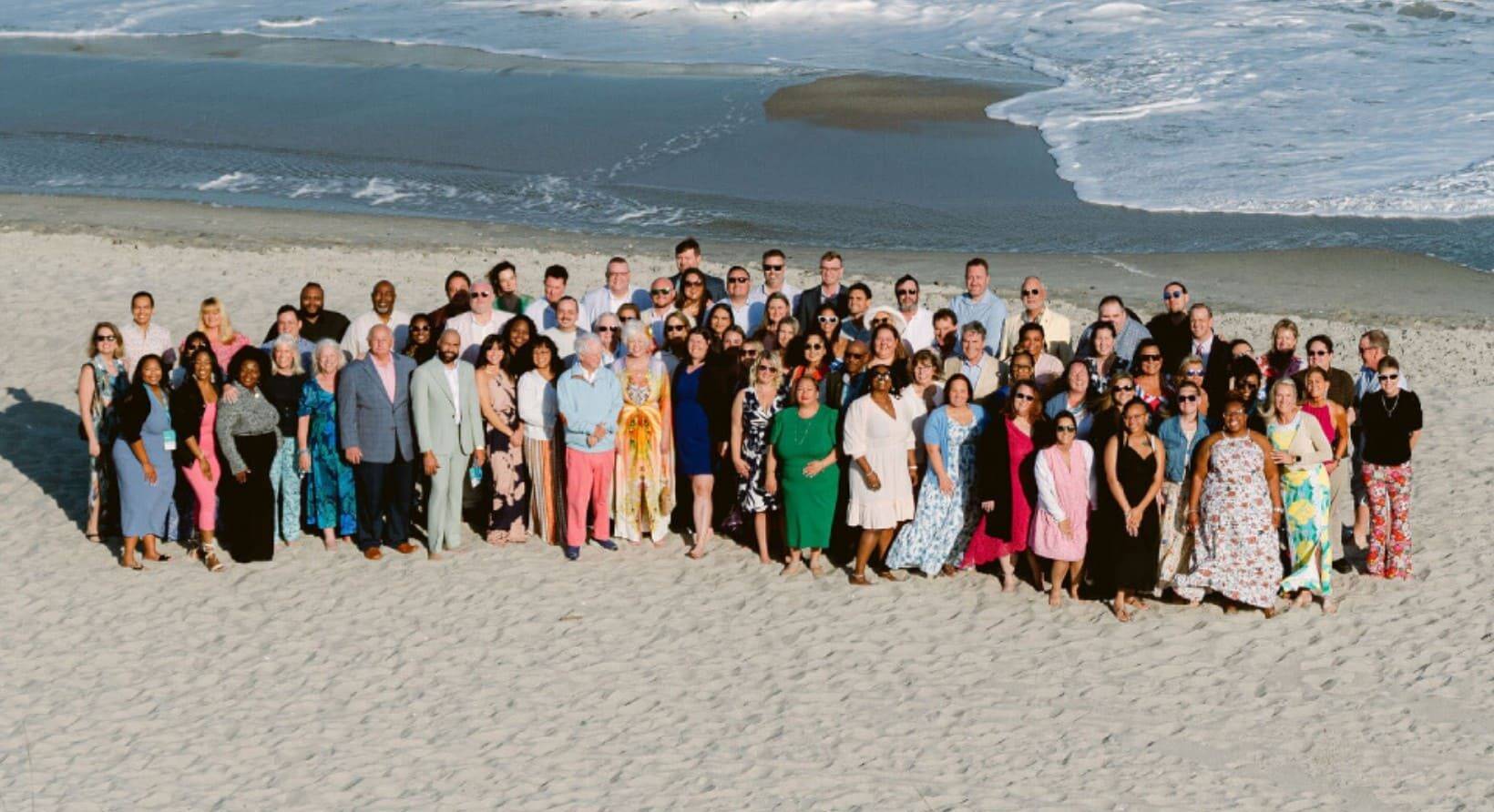 Newport Hospitality Group leadership retreat members posing on the beach