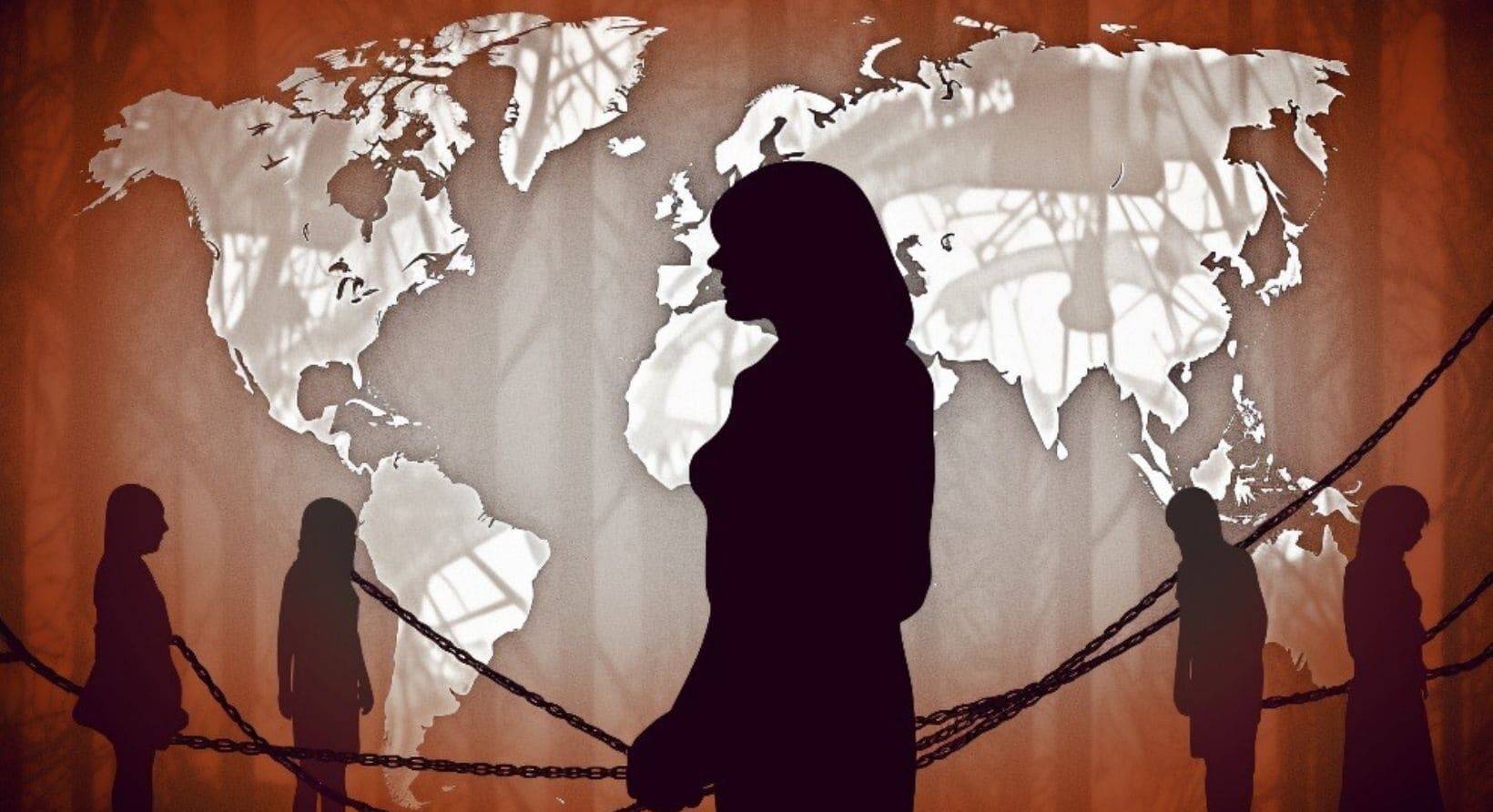 Silhouetted figures bound by chains against a world map backdrop