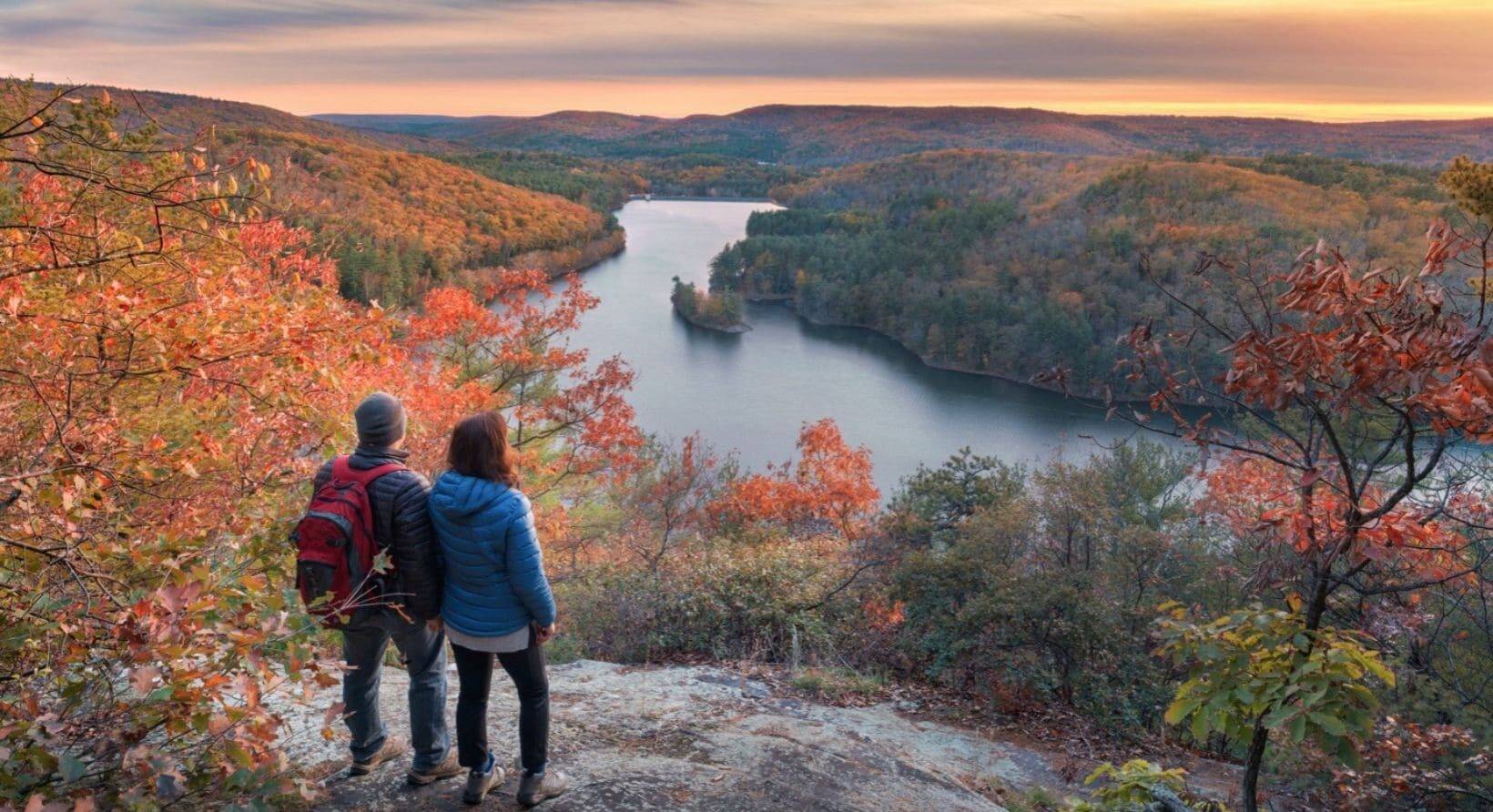 Two hikers looking over a valley in the fall