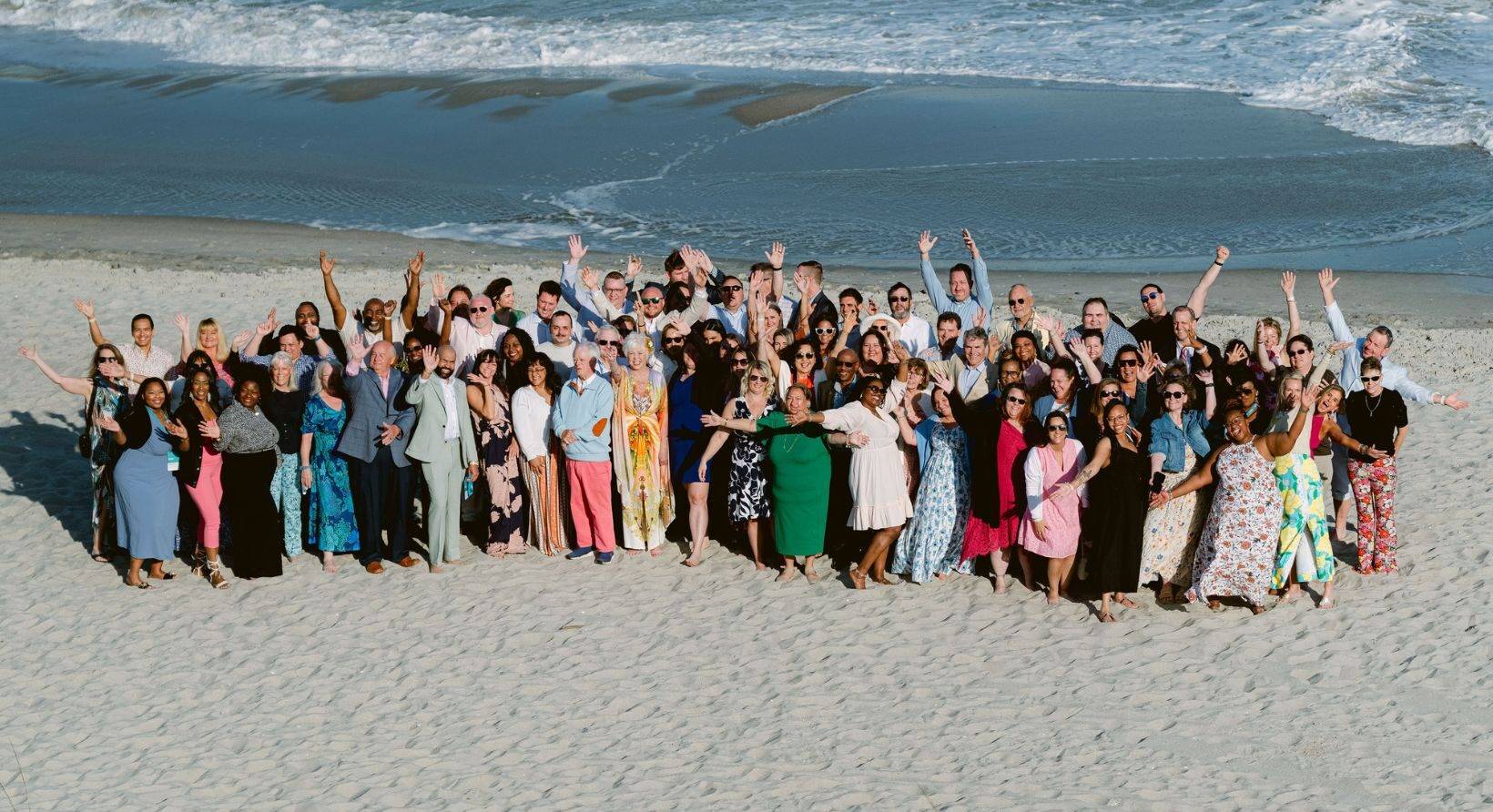 The Newport Hospitality Group team standing on the beach