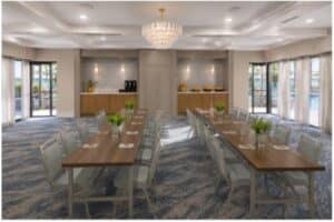 A bright hotel conference room set up with long conference tables