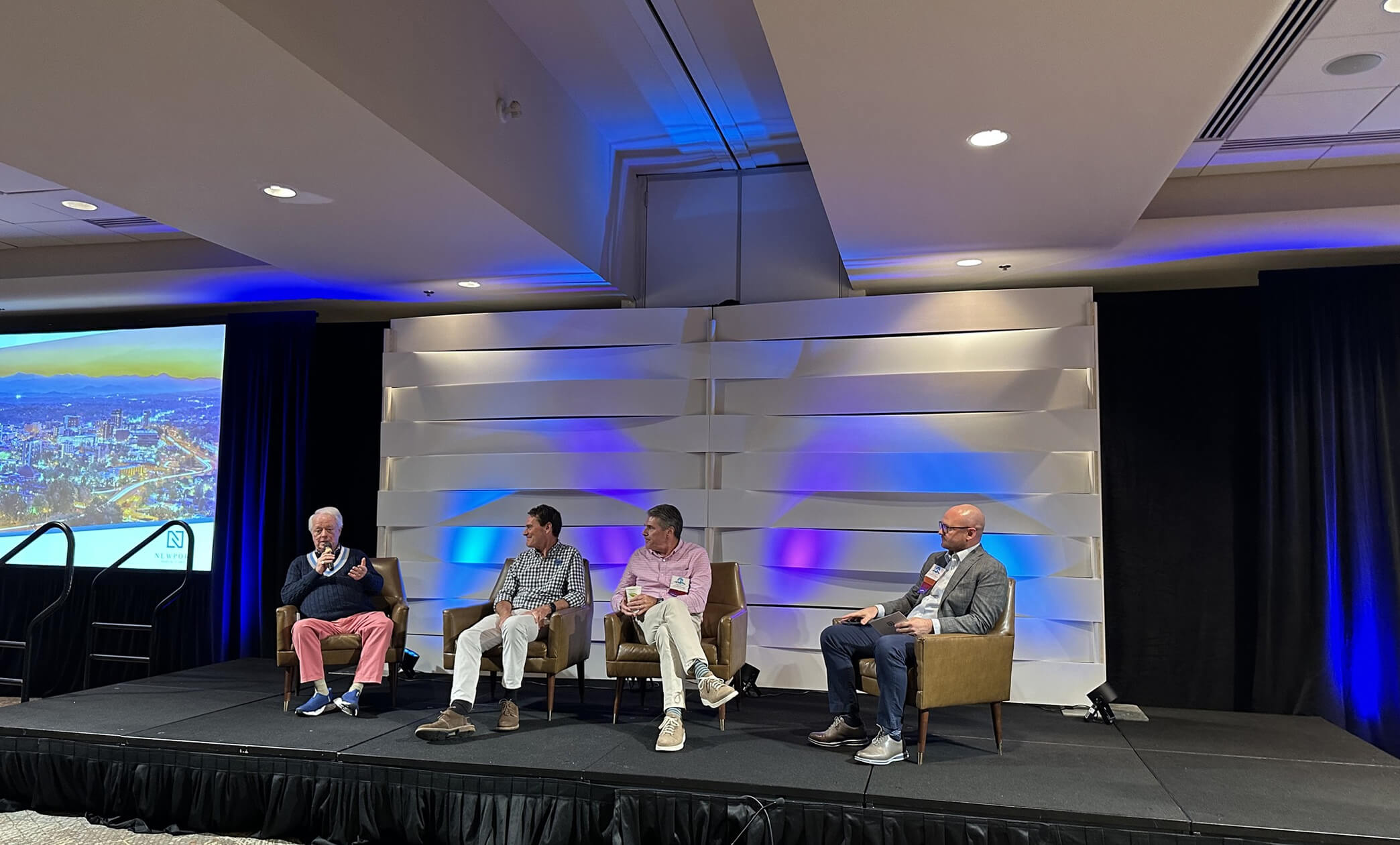 Four men sitting on stage